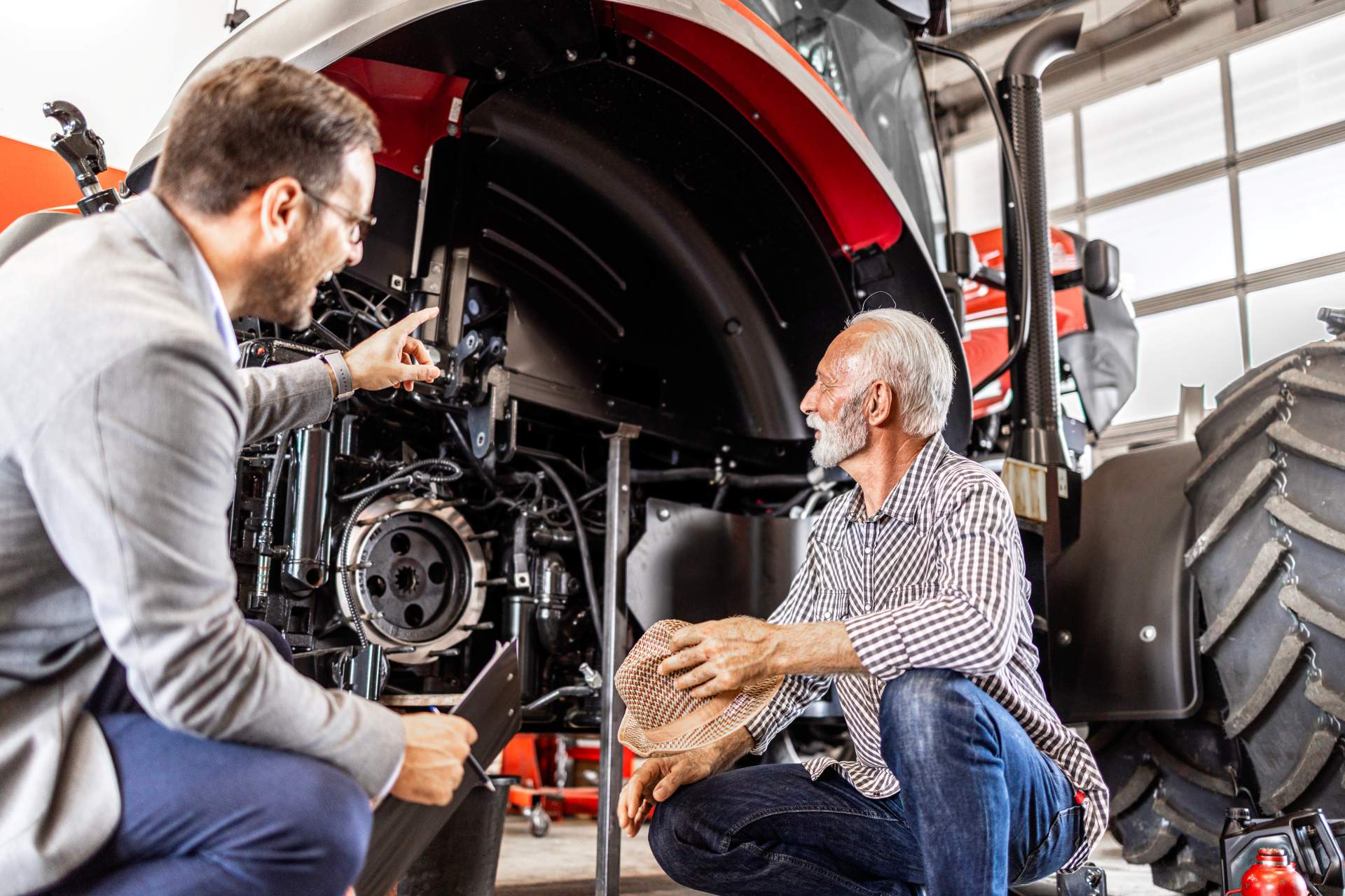 a mechanic and customer viewing a tractor